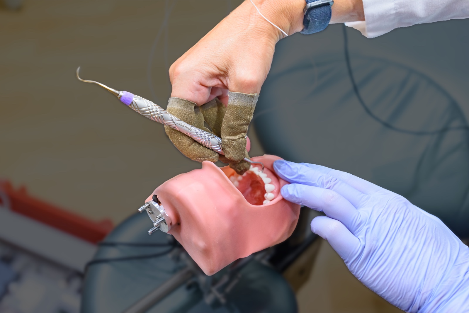 Hygiéniste testant un instrument Harmony sur un modèle dentaire